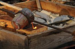 Pouring bronze into sand molds